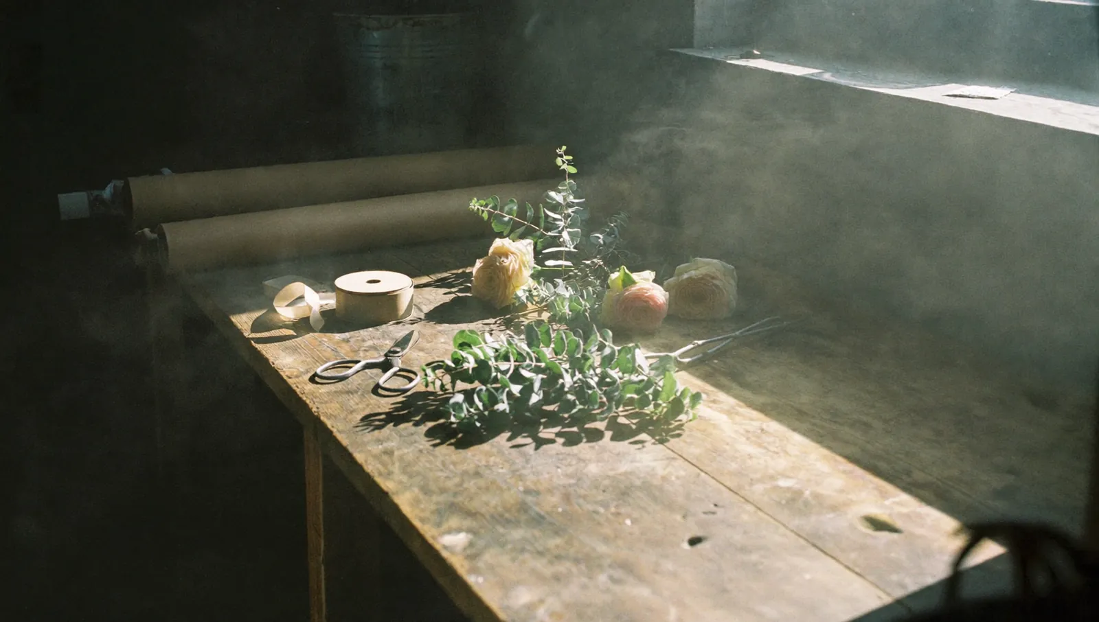 Établi de fleuriste, kraft et sécateur dans la lumière du matin, image d’ambiance générée